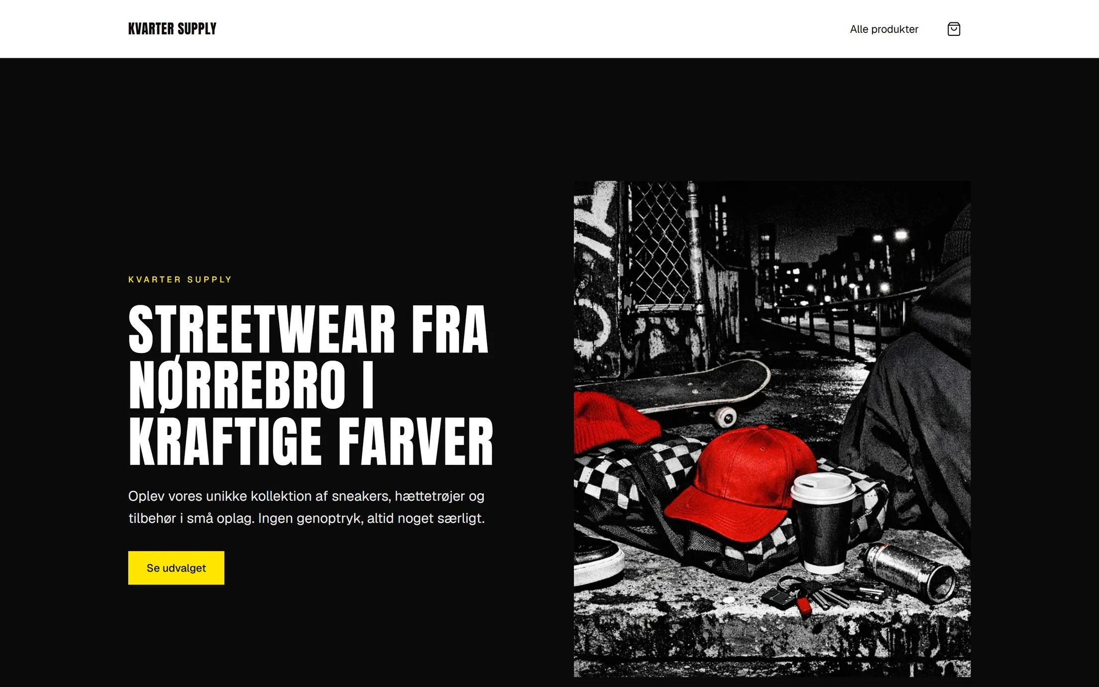 Demobutikken Kvarter Supply på en computerskærm: hvid header med navnet i kondenseret versal-skrift, en sort hero med overskriften 'Streetwear fra Nørrebro i kraftige farver' i store versaler, en gul knap 'Se udvalget', og ved siden af et AI-lavet flash-foto af en rød kasket, et skateboard og en kop på en gade om natten.