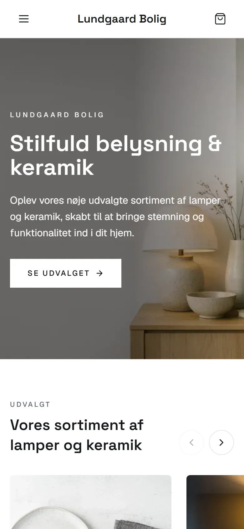 Demobutikken Lundgaard Bolig på en telefon: hero med stemningsbillede og overskrift, derunder 'Udvalgt' med pile til et slideshow af produkter.